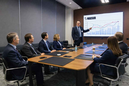 Person giving a presentation on a screen to a group of people in a conference room.