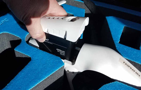 drone battery being inserted into travel while in the drone carrying case