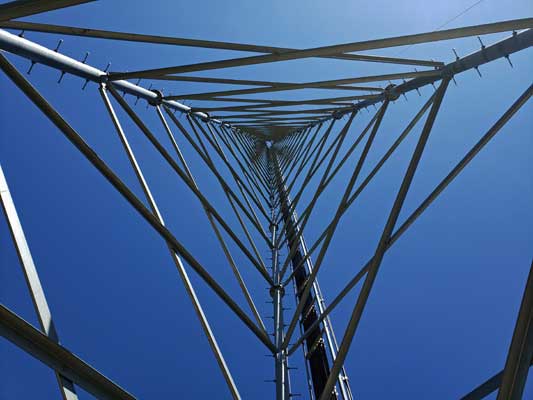 Close-up of a metal lattice structure against a clear blue sky