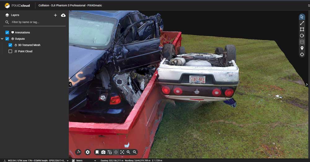 A 3D digital render showing a severe car collision inside a red truck bed, displayed within software user interface panels on a grassy background.