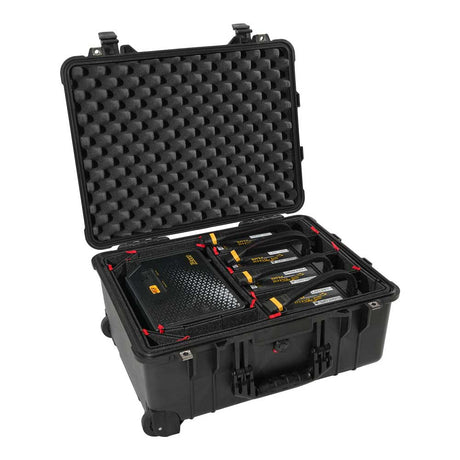 An open black hard-shell carrying case with foam padding, shown on a white background. Inside the case are several black rectangular devices with yellow and white labels, arranged in custom foam compartments.