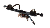 A black carbon fiber plate with integrated mounting brackets, a braided black cable, and a small orange-and-black electronic control module, isolated on a white background.