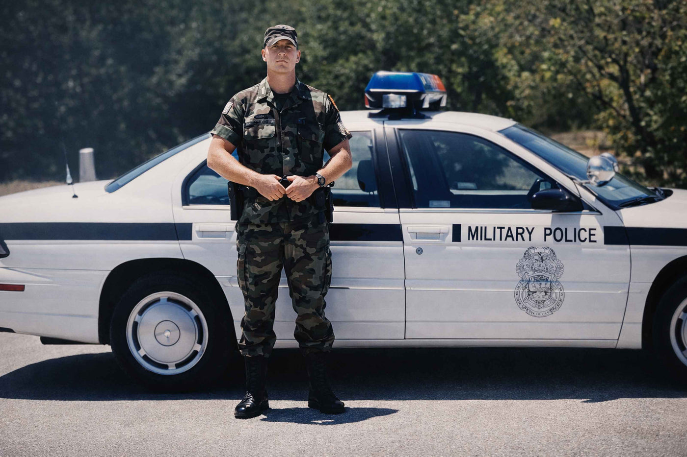 Person in military uniform standing next to a military police vehicle
