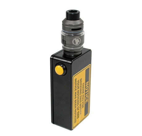 A black covert vape camera with a yellow button and a yellow warning label, topped with a clear and black tank, on a white background.
