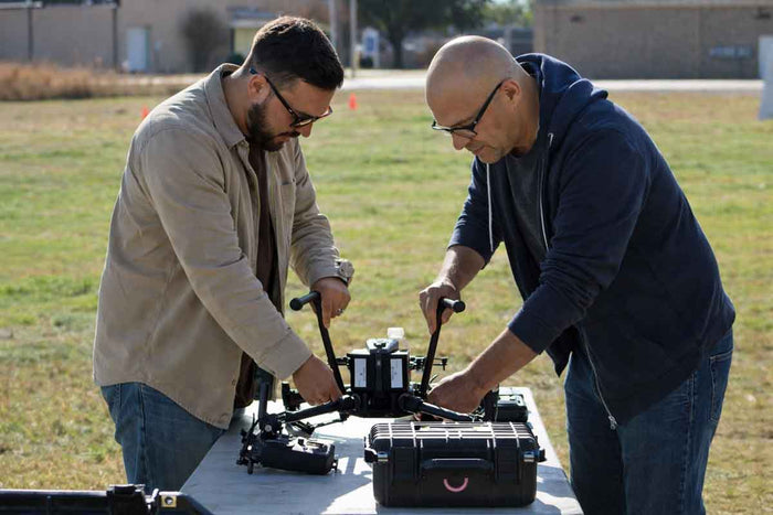 Two men working on equipment in an outdoor setting