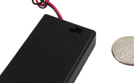 A black plastic body wire battery compartment cover with red and black wires attached, shown next to a US quarter for scale on a white background.