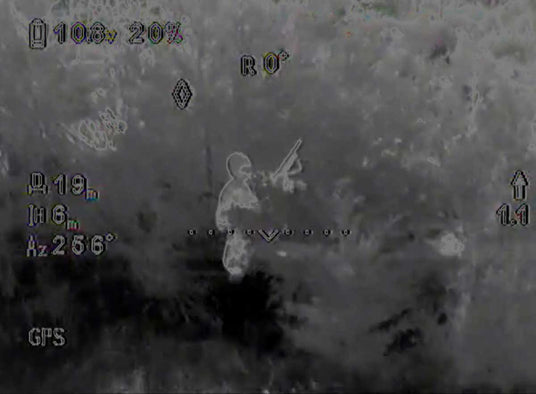 Image from drone with thermal camera spotting suspect with firearm