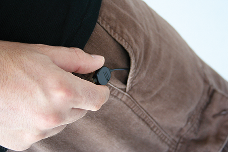 slim profile audio body wire being slipped into pants pocket
